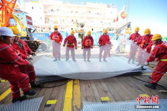 作业人员在准备沉船封窗用的铁丝网。 中新社记者 申海 摄